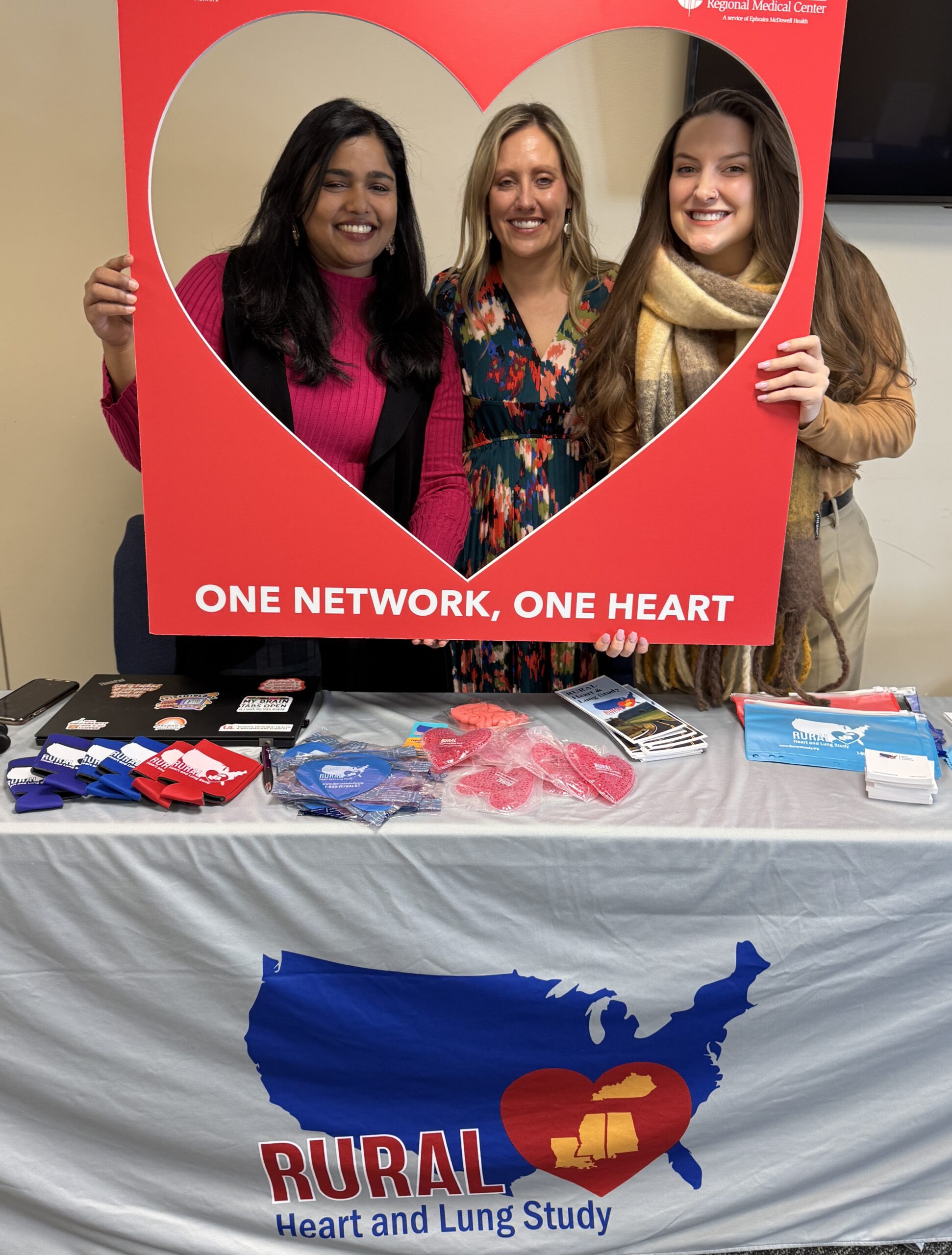 Stephanie Boone, Scottland Stewart, and Stephie Abraham posted inside of a heart shaped cutout at the Happy Heart Luncheon