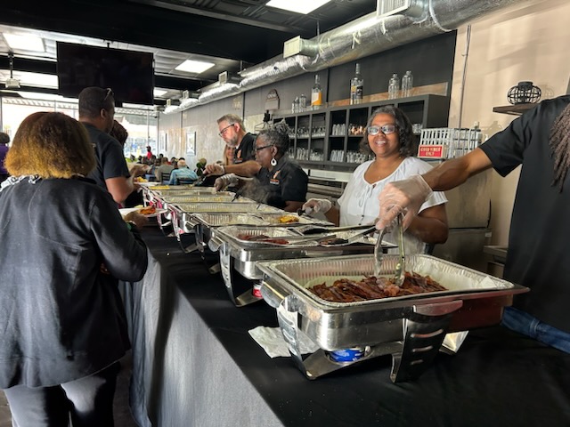 people serving others at food buffet