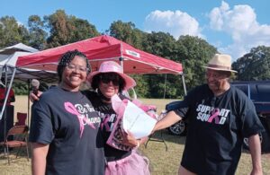 two women and a man posing and smiling