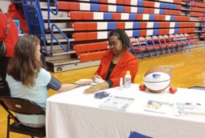 woman taking another woman's BP at table