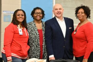 three woman and a man smiling