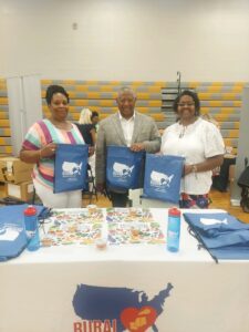 three people holding rural tote bags smiling