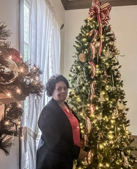 woman standing next to christmas tree