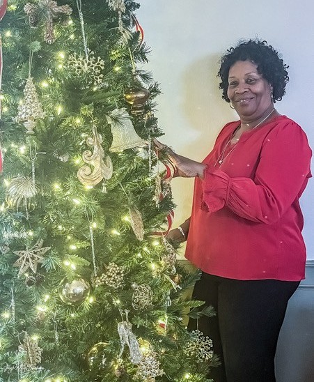 woman smiling next to christmas tree
