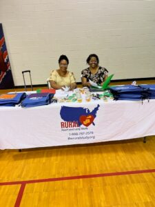 two woman at RURAL info table smiling