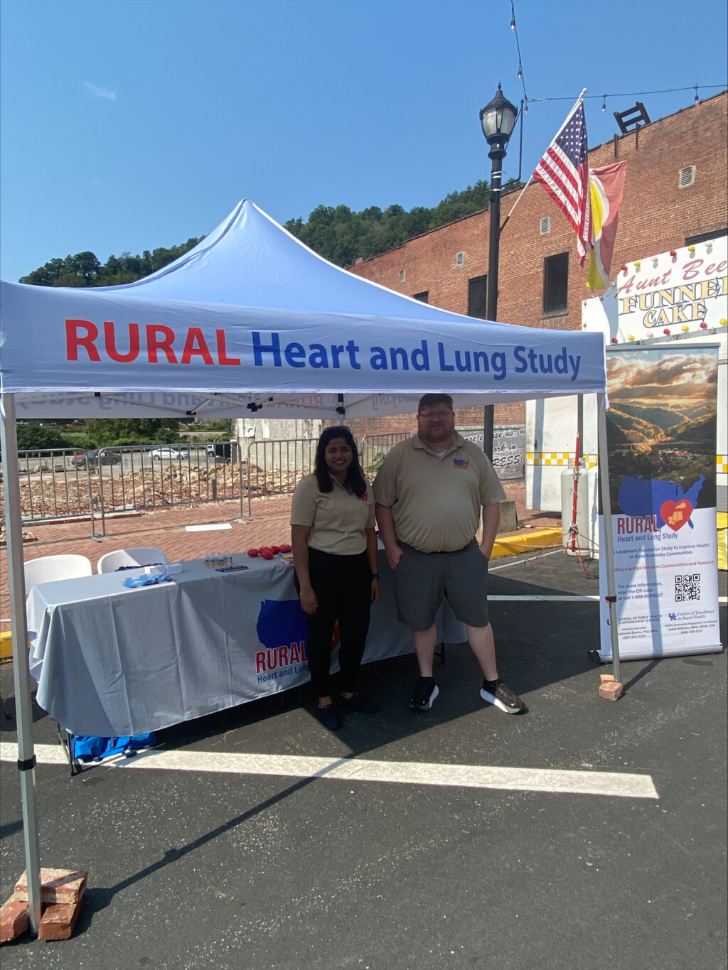 Caleb Williams and Stephie Abraham standing in front of RURAL table