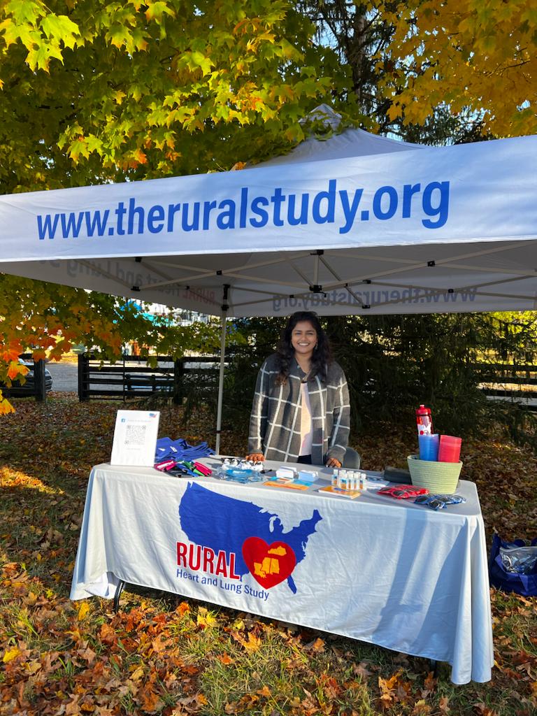 Stephie Abraham smiling standing behind RURAL table